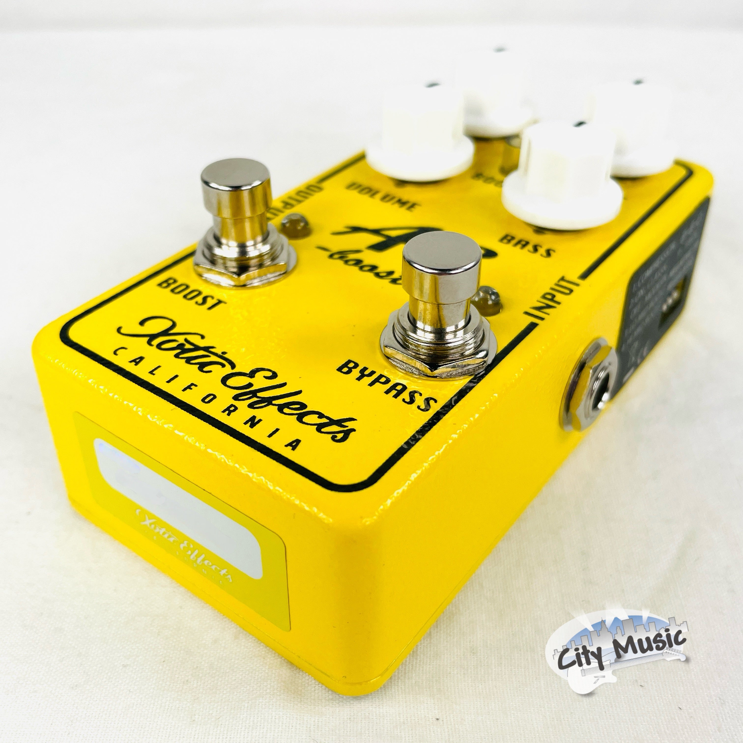 Xotic AC Booster V2 pedal — yellow enclosure, side view with jacks