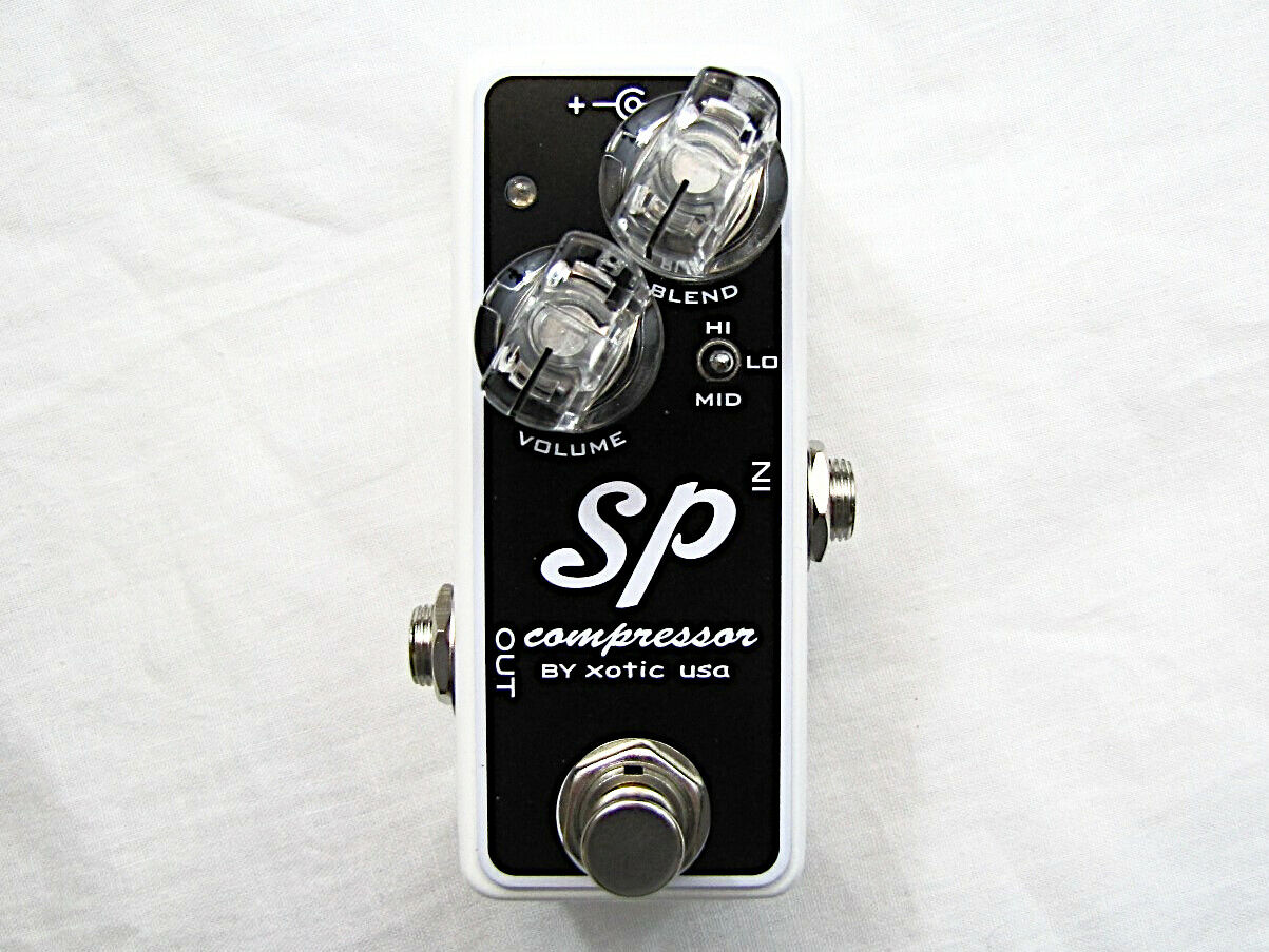 Xotic SP Compressor mini guitar pedal — black faceplate on white enclosure, top view